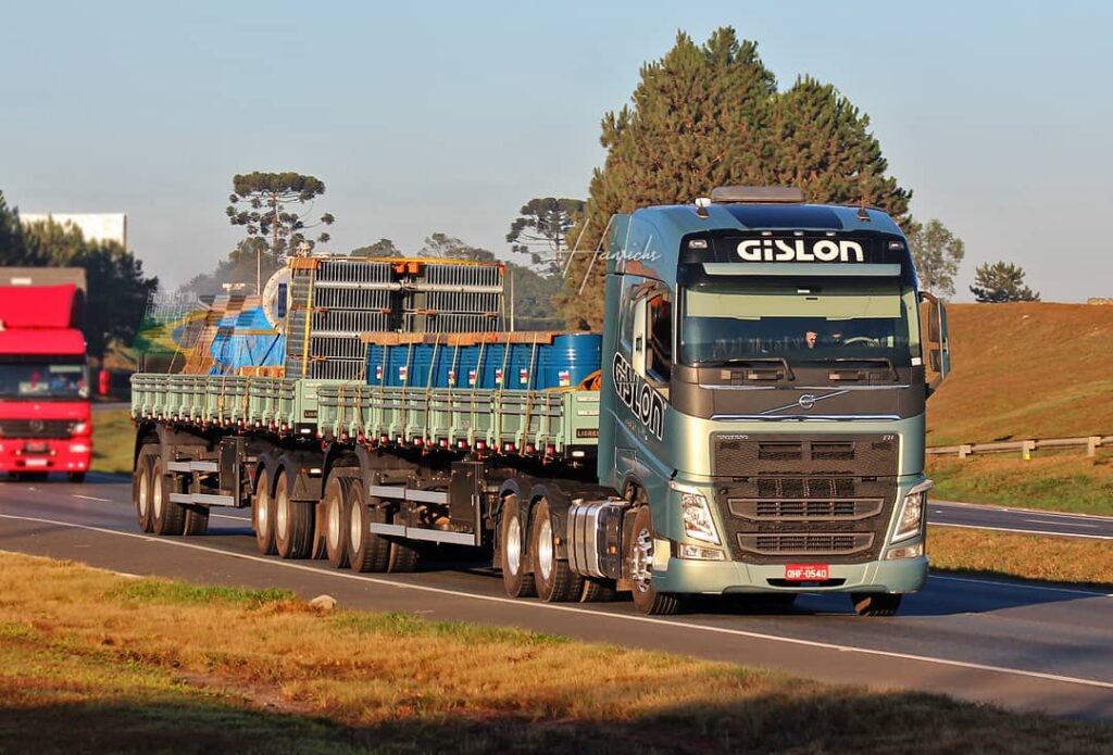 Caminhão Gislon transportando materiais de construção ao entardecer